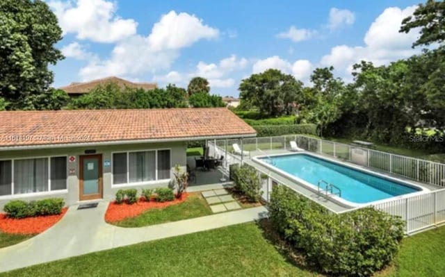 view of swimming pool featuring a lawn and a patio