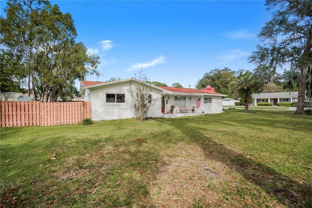 rear view of house featuring a lawn