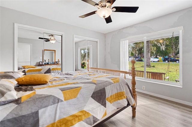 bedroom featuring light hardwood / wood-style floors, multiple windows, and ceiling fan