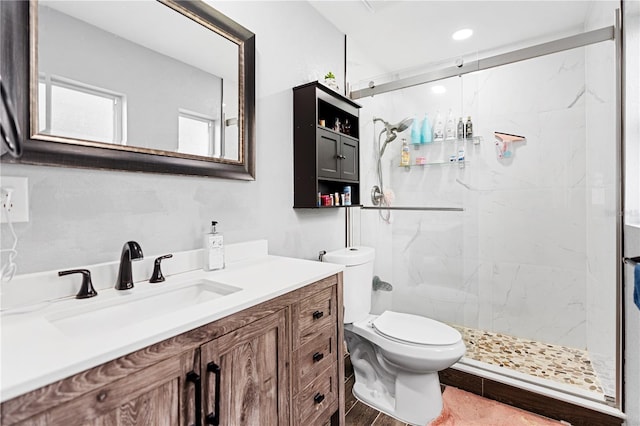 bathroom featuring hardwood / wood-style floors, vanity, toilet, and tiled shower