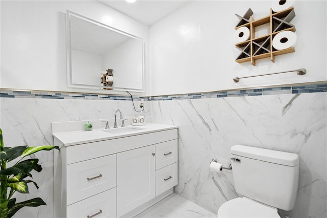 bathroom with vanity, tile walls, and toilet