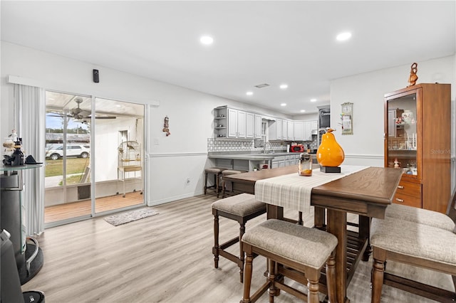 dining room featuring ceiling fan, light hardwood / wood-style floors, and sink