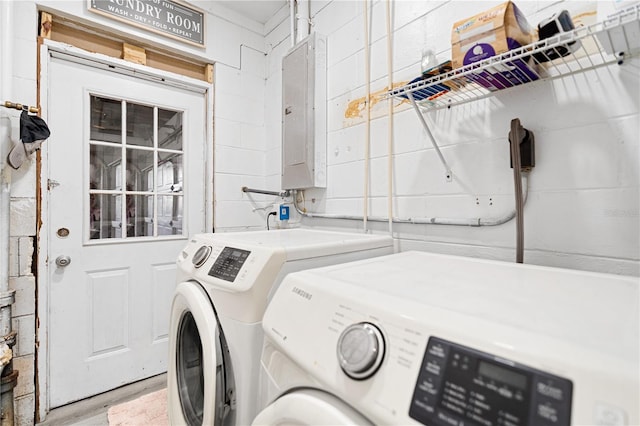 clothes washing area with separate washer and dryer, electric panel, and hardwood / wood-style flooring