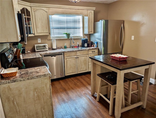 kitchen featuring light brown cabinetry, sink, stainless steel appliances, and dark hardwood / wood-style floors