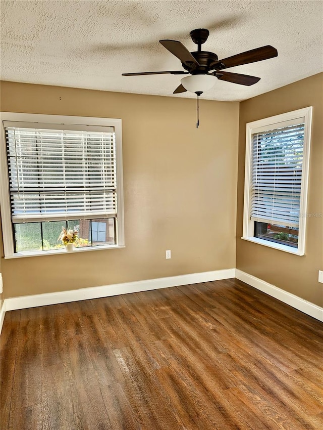 unfurnished room with a textured ceiling, a wealth of natural light, and dark wood-type flooring