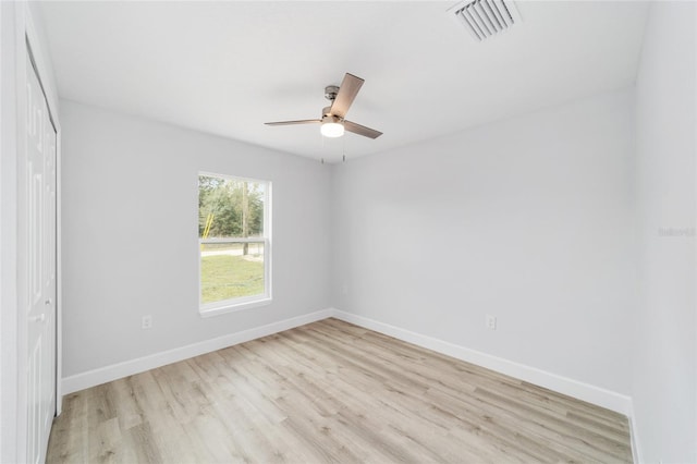 empty room with ceiling fan and light hardwood / wood-style flooring