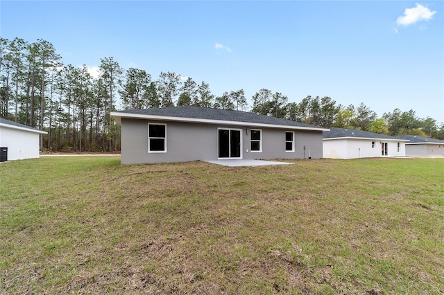 back of property with a lawn, a patio, and stucco siding