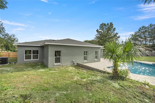 back of house with a yard, a fenced in pool, and cooling unit