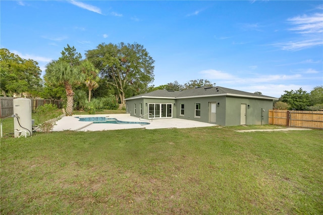 back of house with a fenced in pool, a patio, and a yard