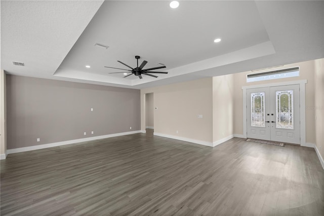 interior space with french doors, dark hardwood / wood-style floors, ceiling fan, and a tray ceiling