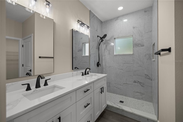 bathroom featuring vanity, hardwood / wood-style floors, and a tile shower