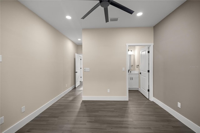 interior space with dark hardwood / wood-style floors, ceiling fan, and ensuite bath