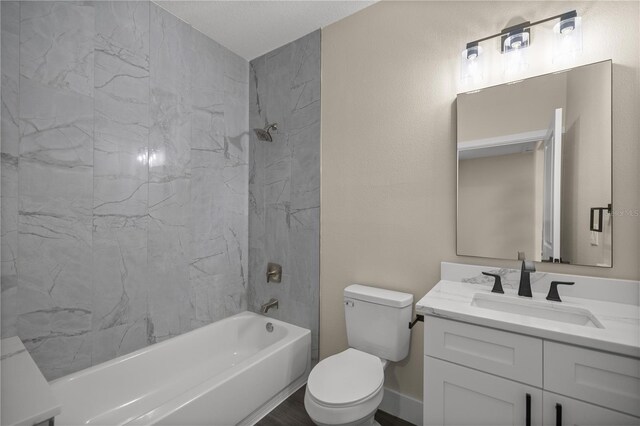 full bathroom featuring tiled shower / bath, vanity, toilet, and hardwood / wood-style floors