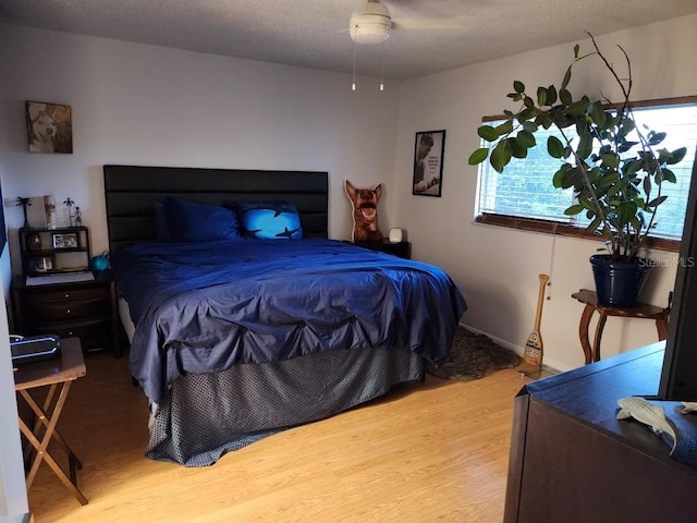 bedroom featuring hardwood / wood-style floors and a textured ceiling