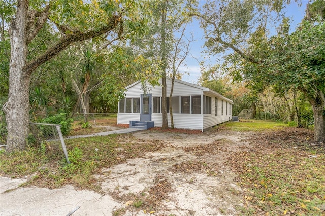 view of front of property featuring cooling unit and a sunroom