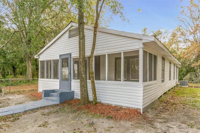 view of side of property featuring a sunroom and cooling unit