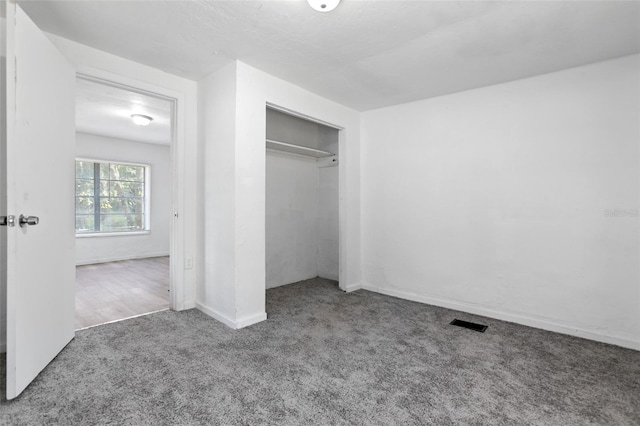 unfurnished bedroom featuring carpet and a closet