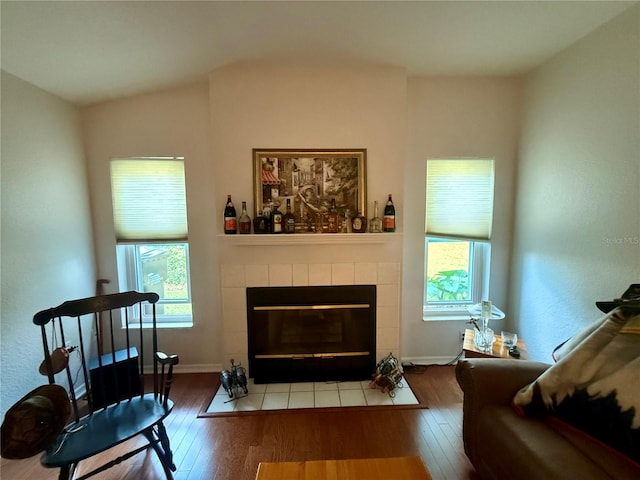 sitting room with a tile fireplace, hardwood / wood-style flooring, and a wealth of natural light