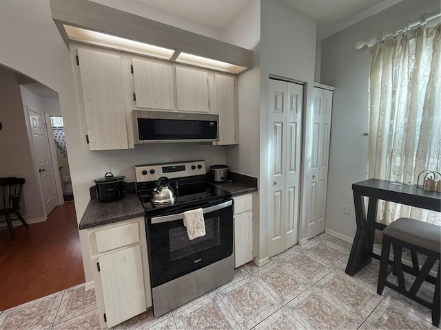 kitchen featuring plenty of natural light, light hardwood / wood-style floors, vaulted ceiling, and appliances with stainless steel finishes