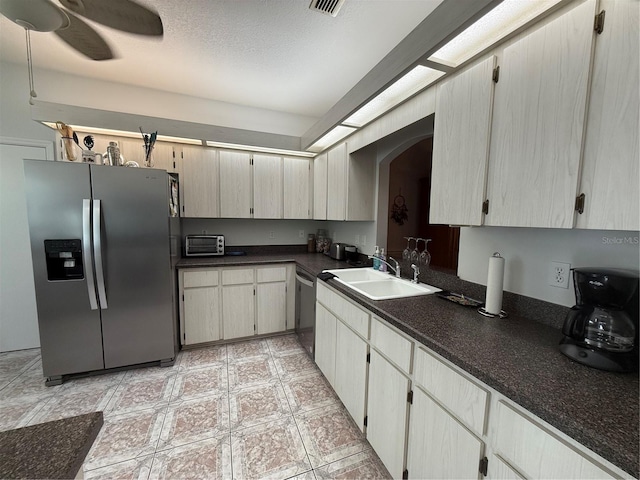 kitchen featuring ceiling fan, sink, a textured ceiling, light tile patterned floors, and appliances with stainless steel finishes