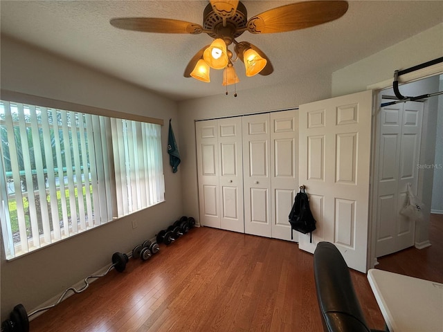 unfurnished bedroom featuring ceiling fan, dark hardwood / wood-style floors, and a textured ceiling