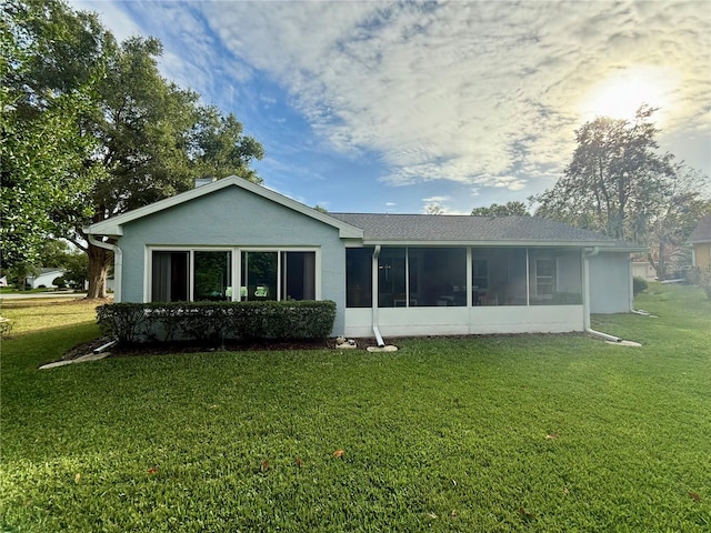 back of property featuring a sunroom and a yard