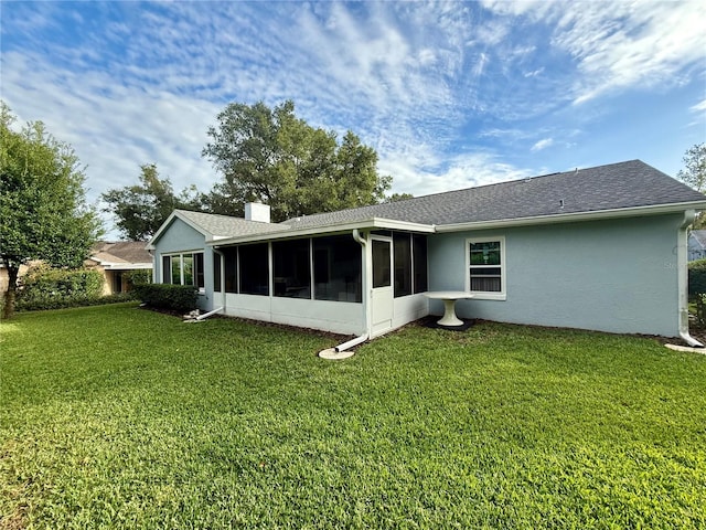 back of property featuring a sunroom and a yard