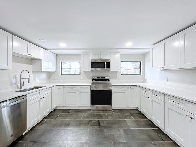 kitchen with white cabinets, appliances with stainless steel finishes, and sink