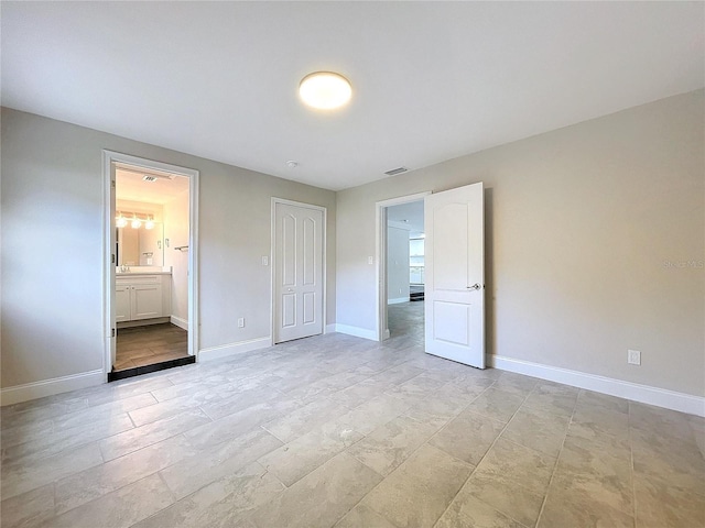 unfurnished bedroom featuring connected bathroom and a closet