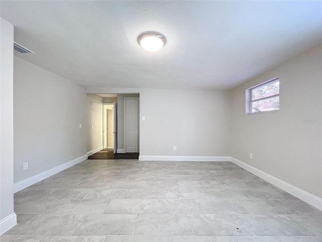 unfurnished room with a textured ceiling