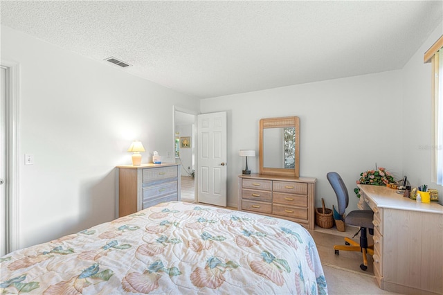 bedroom with a textured ceiling and light carpet