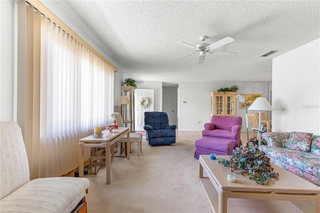 living room featuring ceiling fan, a textured ceiling, and light carpet