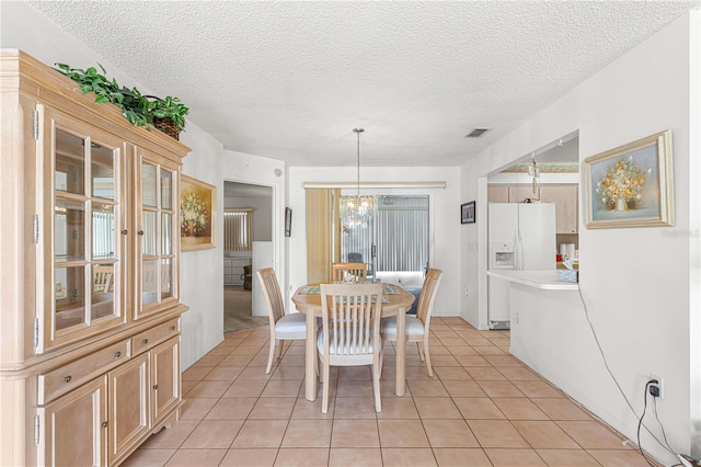 dining room with light tile patterned flooring, a textured ceiling, a wealth of natural light, and an inviting chandelier