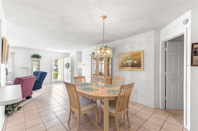 dining room featuring light tile patterned floors, a textured ceiling, and a notable chandelier