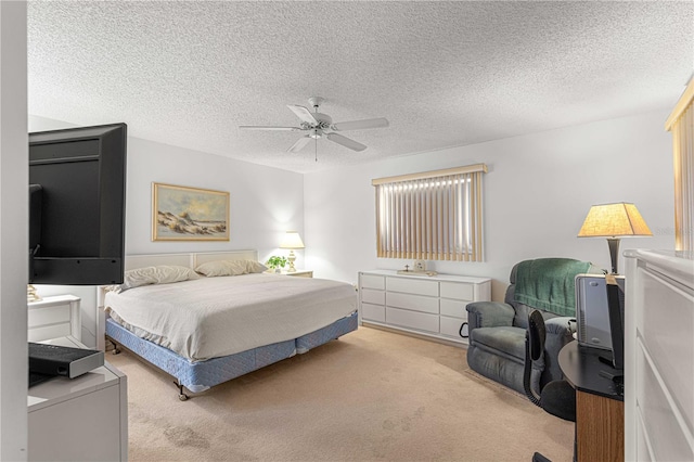 bedroom featuring ceiling fan, light colored carpet, and a textured ceiling