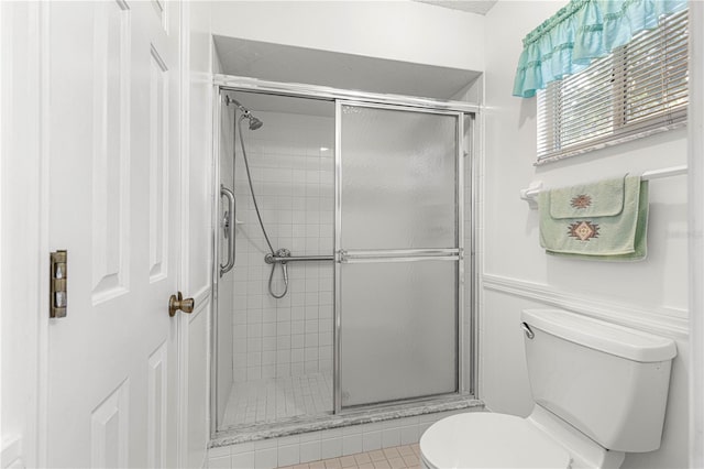 bathroom featuring toilet, tile patterned floors, and walk in shower