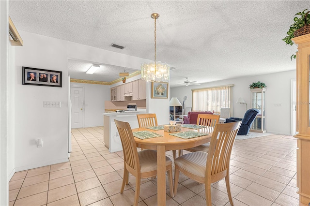 dining room featuring ceiling fan with notable chandelier, a textured ceiling, and light tile patterned flooring