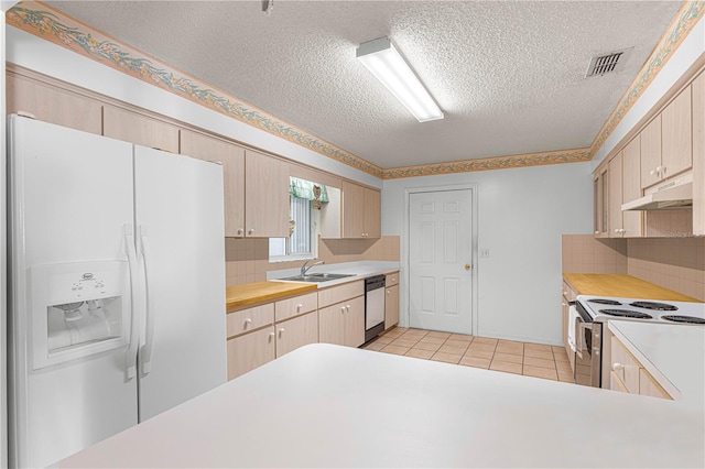 kitchen with backsplash, light brown cabinetry, and white appliances