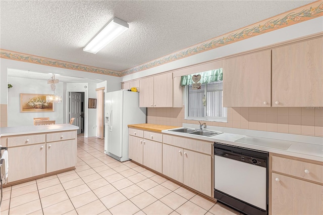 kitchen featuring backsplash, white appliances, a textured ceiling, sink, and pendant lighting