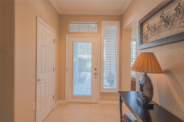 doorway to outside featuring light tile patterned flooring, crown molding, and baseboards