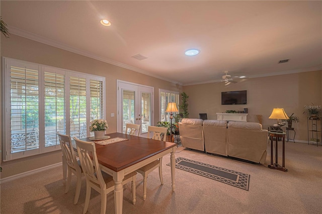 dining area with light carpet, ceiling fan, and crown molding