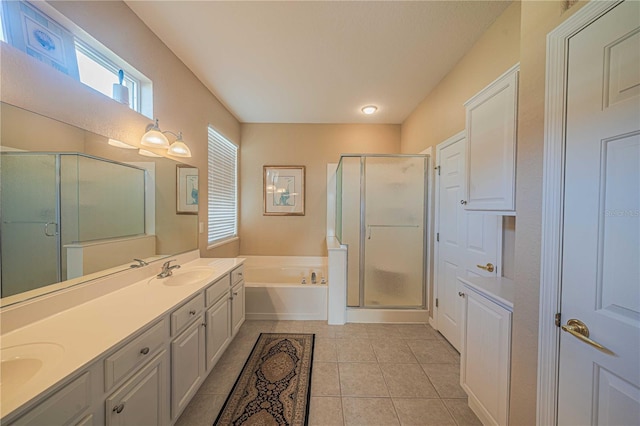 bathroom with double vanity, a stall shower, a garden tub, tile patterned flooring, and a sink