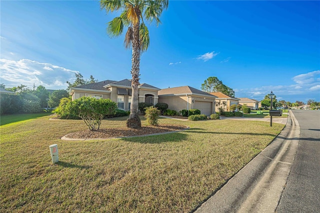 view of front of property with driveway, a garage, a front lawn, and stucco siding