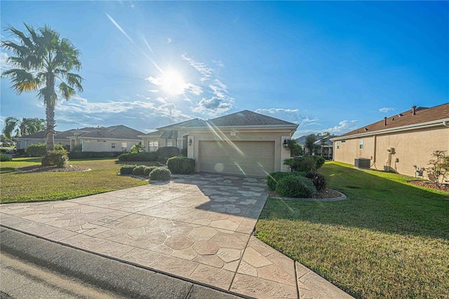 ranch-style house with central air condition unit, a front yard, and a garage