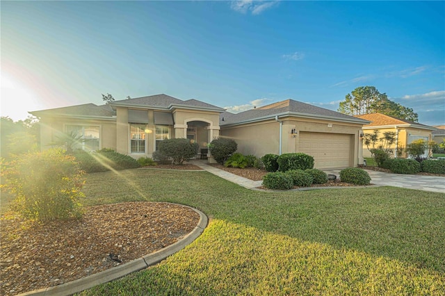 view of front of property featuring a garage, concrete driveway, a front lawn, and stucco siding