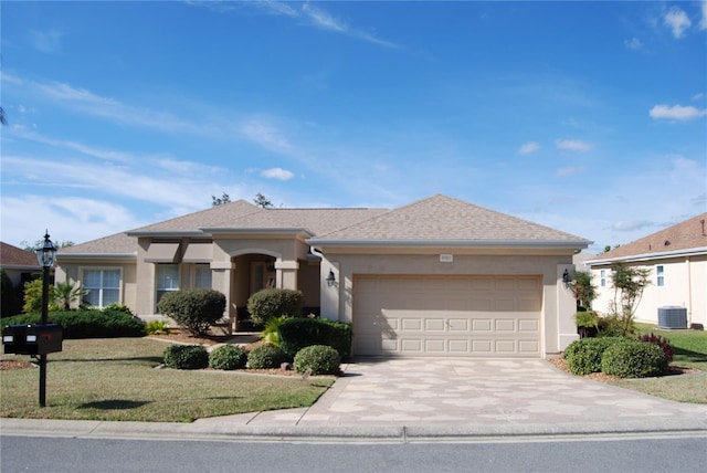 ranch-style house with stucco siding, concrete driveway, central AC unit, a garage, and a front lawn