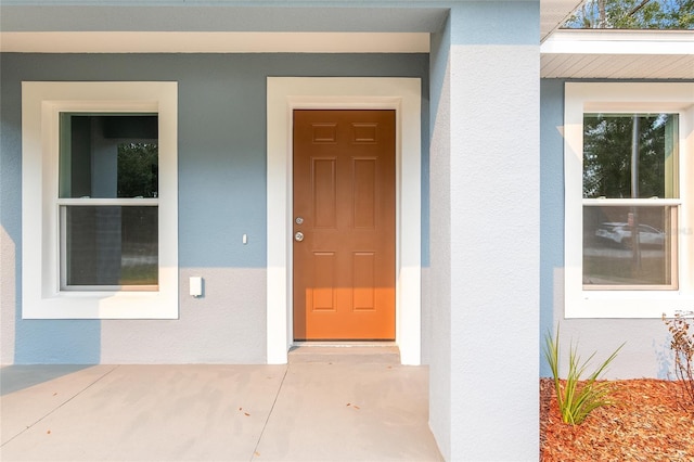 entrance to property featuring stucco siding