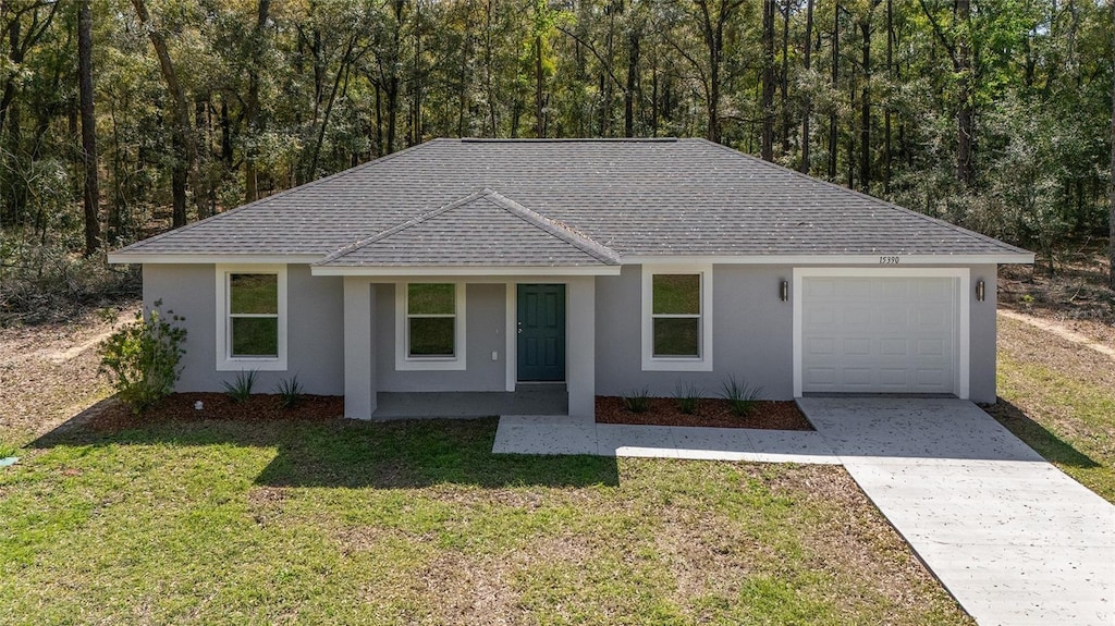 ranch-style home with stucco siding, a shingled roof, concrete driveway, a garage, and a front lawn