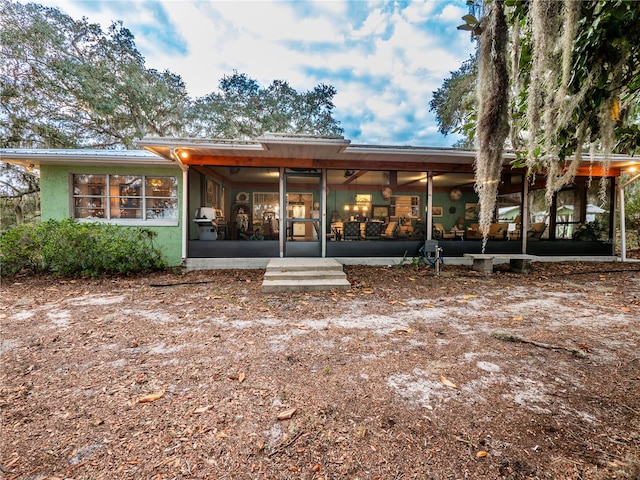 rear view of property featuring a sunroom