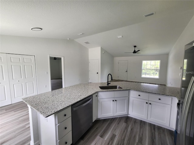 kitchen with lofted ceiling, white cabinetry, sink, and stainless steel appliances